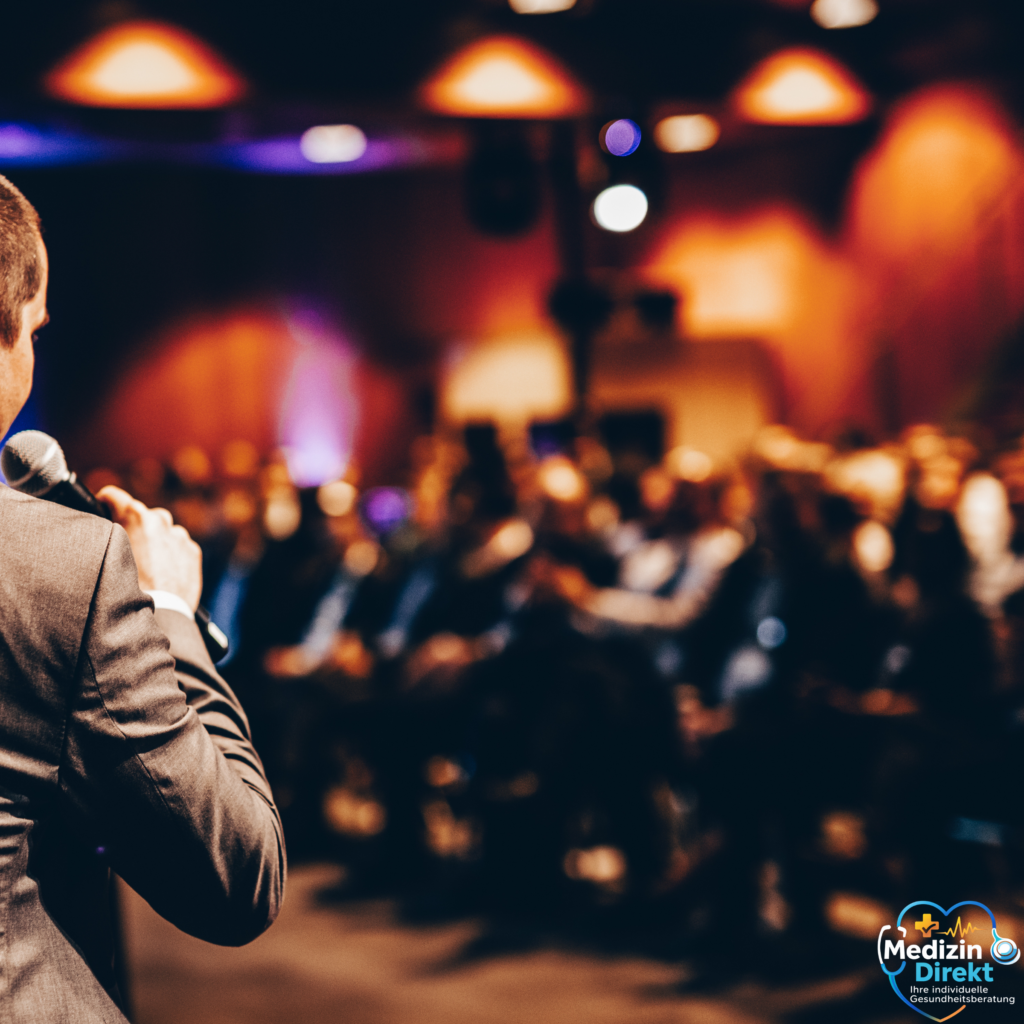 Moderator spricht mit Mikrofon vor Publikum bei einer Veranstaltung