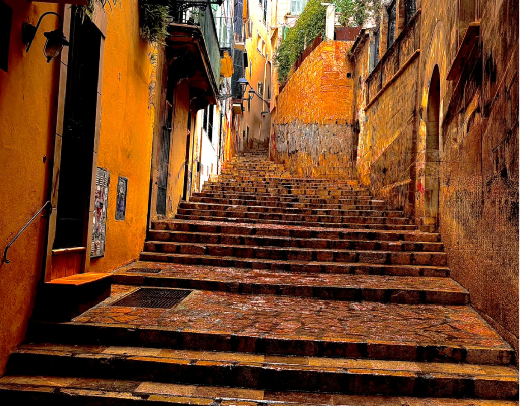 Steinerne Treppe in einer mediterranen Altstadtgasse mit warmen Hausfassaden und aufsteigendem Weg